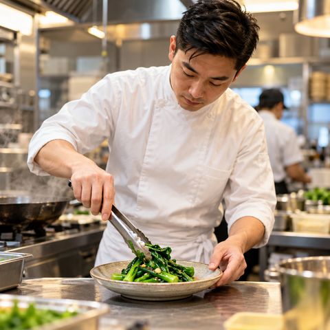 A chef plating stir-fried kailan